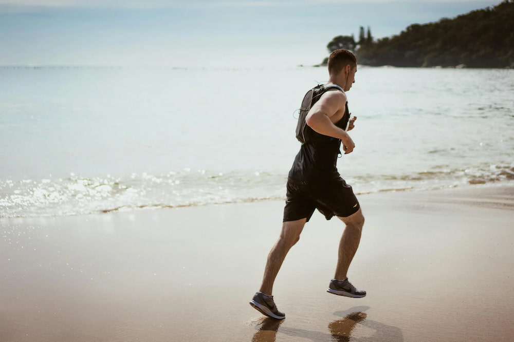 man jogging on beach to cut back on alcohol